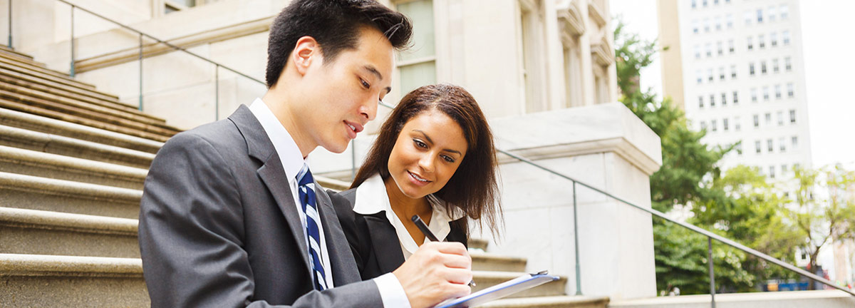 Man and woman business professionals with clipboard sitting on steps Man and woman business professionals with clipboard sitting on steps