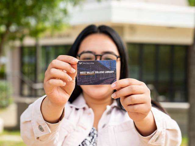 student holding west valley college library community borrower card