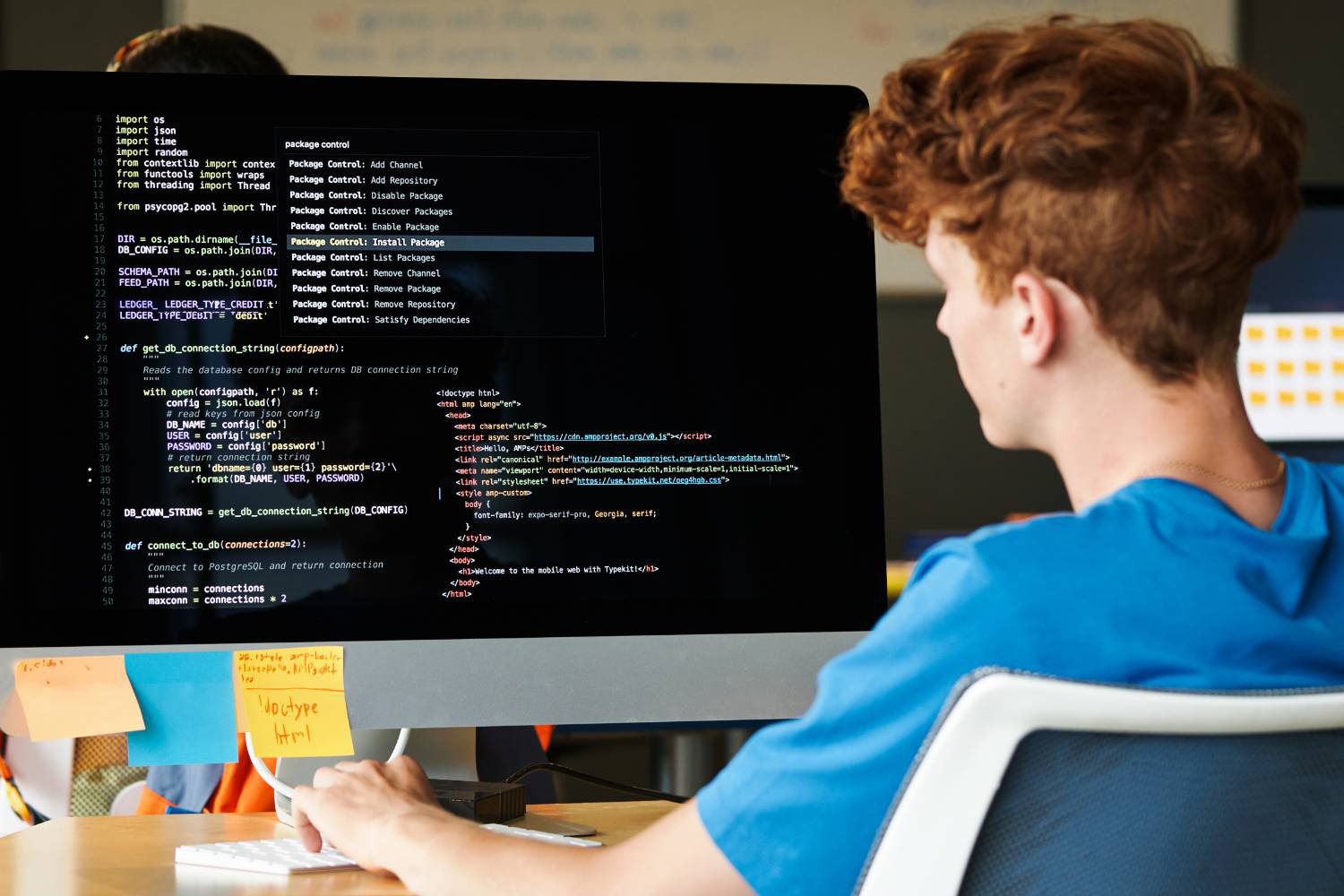 young student looking at computer monitor with code