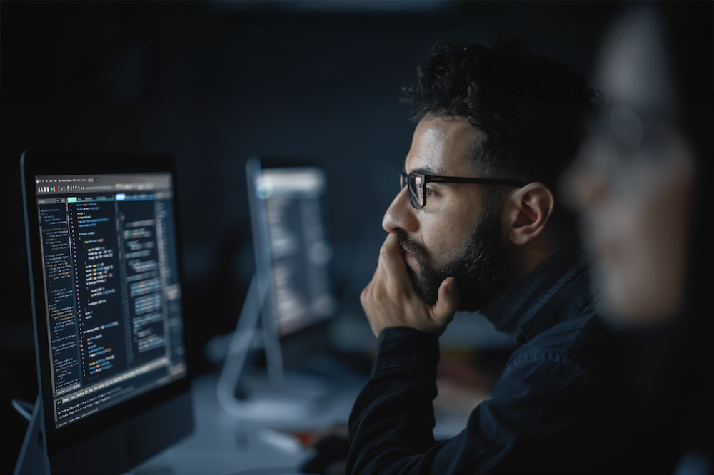 man looking at monitor with code