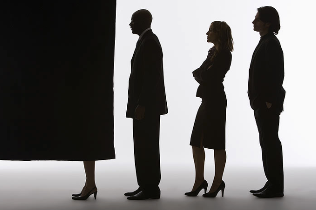 people in line with one covered by a curtain to vote