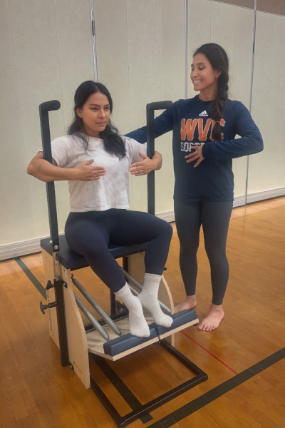 Instructor with student on pilates machine