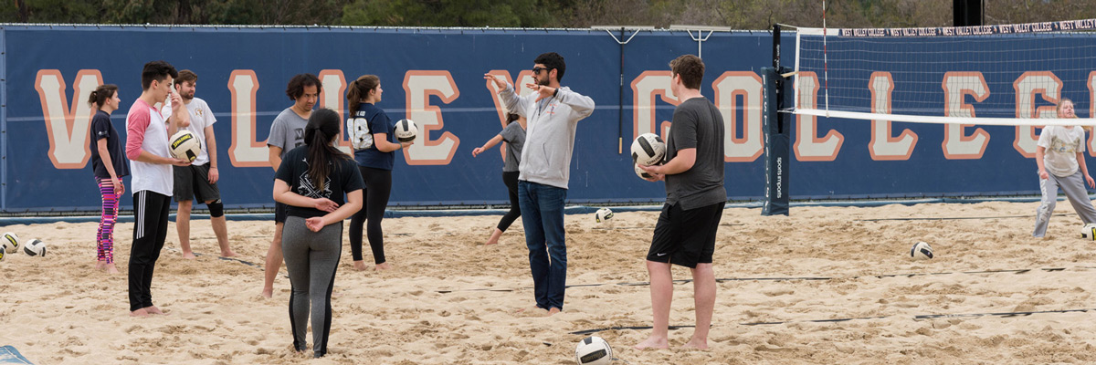 Students on sand court during volleyball class