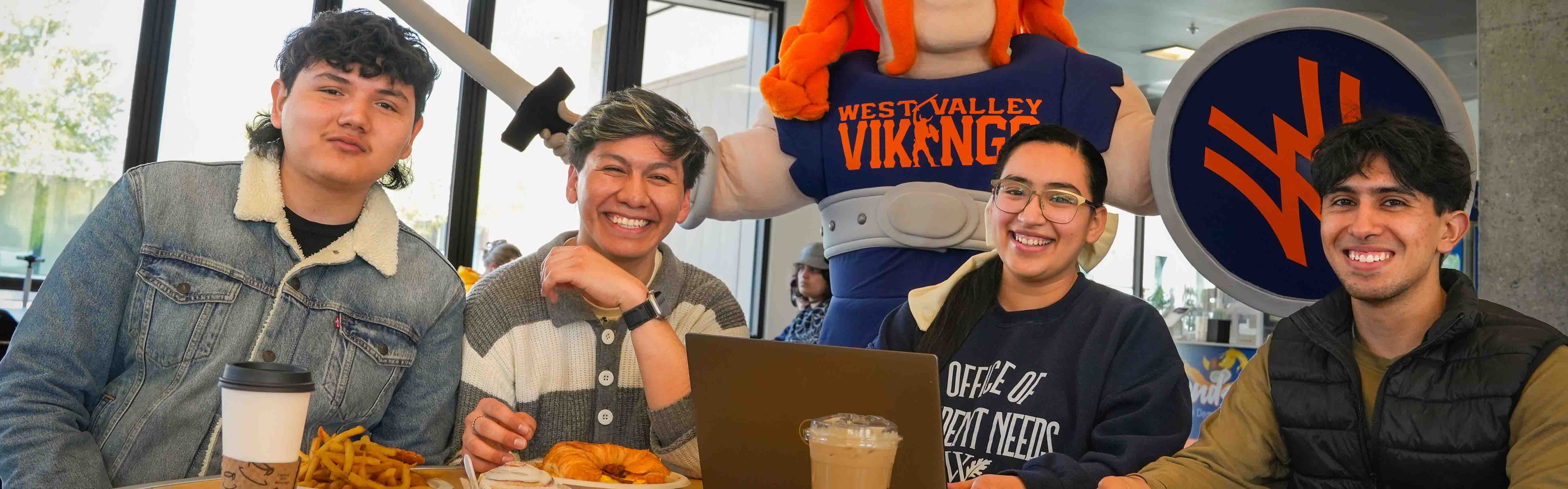 students at a table with meals with viking mascot in background