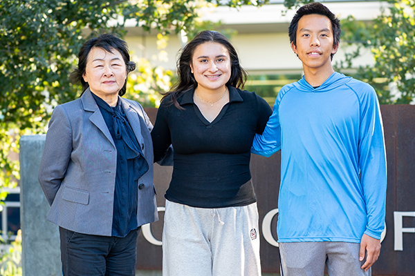 Two students with teacher outside of math and science building